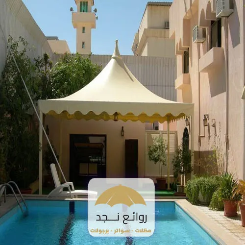 مظلة قماش على مسبح في حوش المنزل